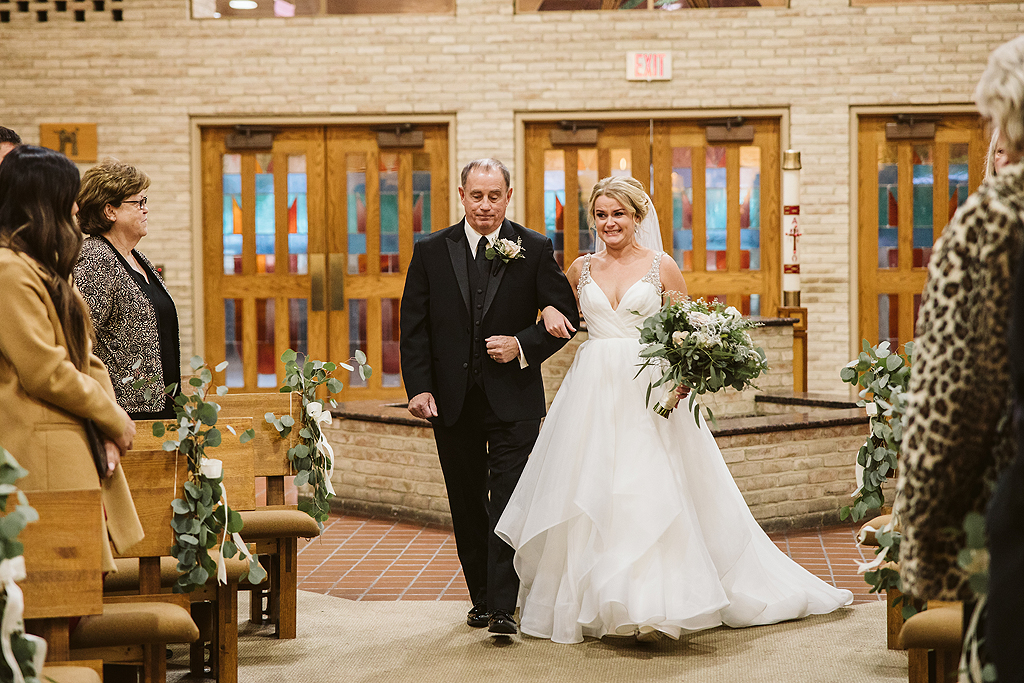 bride walking down aisle with her father on a wedding day
